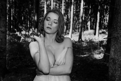 eine frau mit einer spinne im wald